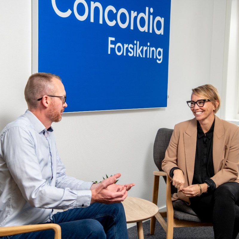 Mand og kvinde sidder overfor hinanden på Concordias kontor og de taler sammen.